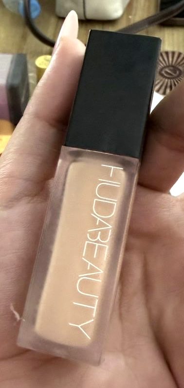 Huda Beauty #FauxFilter foundation bottle held in the hand