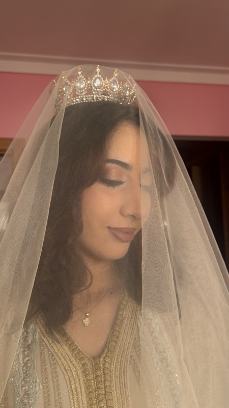 Bride beneath a veil with warm shimmer eyeshadow and a soft nude lip